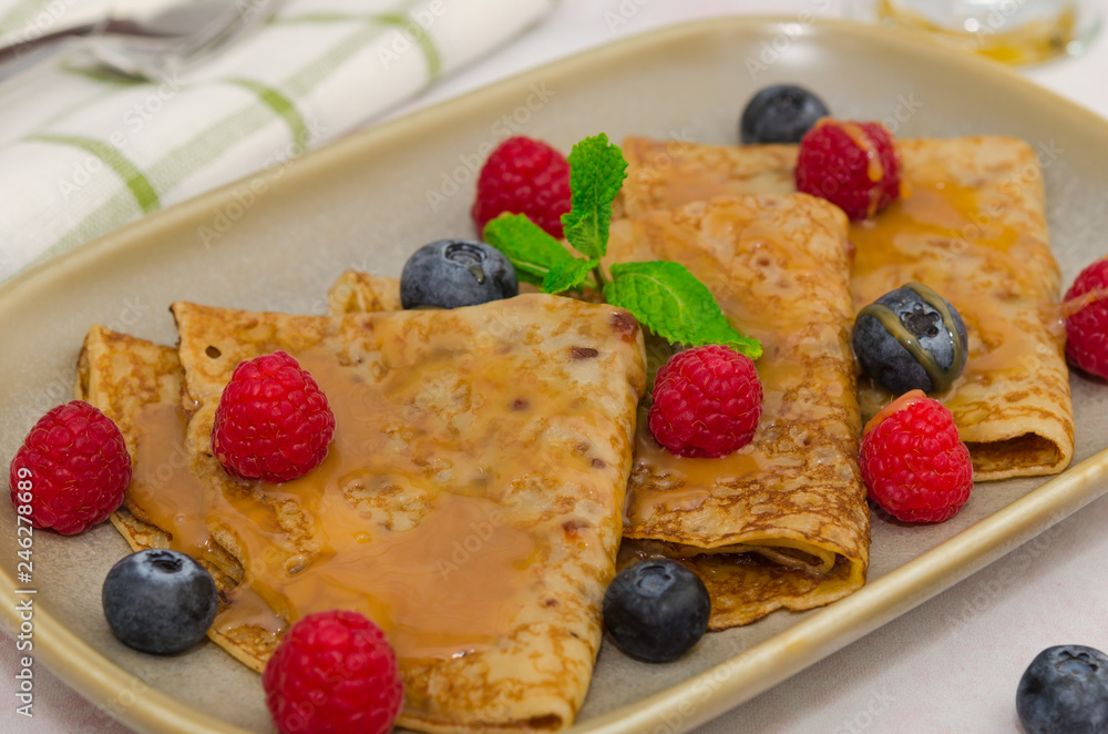 Crepes with berries. Crepes with raspberry, blueberry and caramel sauce. Pancakes Crepes with berries. Crepes with raspberry, blueberry and caramel sauce. Pancakes