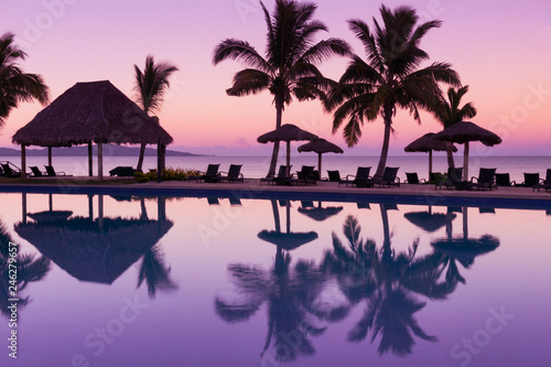 Pinkish purple sunrise colors reflecting in the water in Fiji