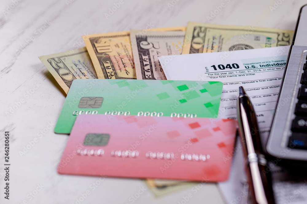 Pay tax concept USA Tax Form 1040 with US dollar bills and for April Calendar Pay tax concept USA Tax Form 1040 with US dollar bills and for April Calendar
