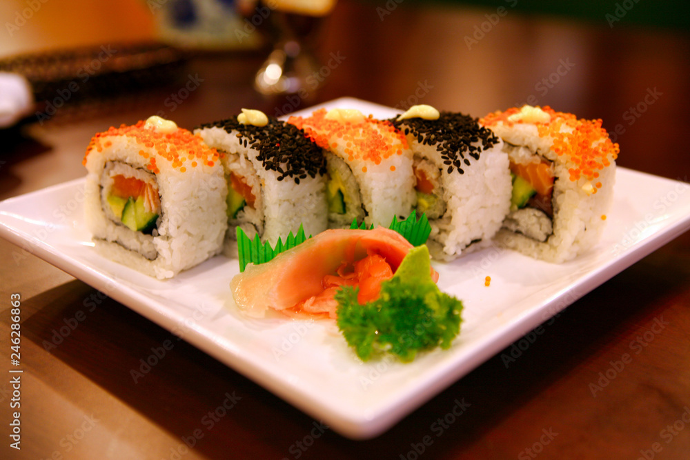 Uramaki rolls with tuna and salmon served on a white plate. Beijing, China. Uramaki rolls with tuna and salmon served on a white plate. Beijing, China.