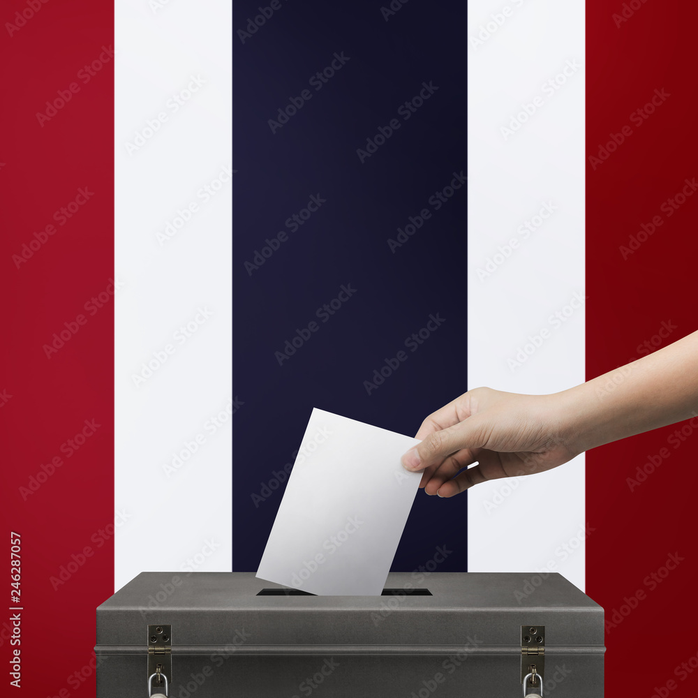 Hand holding ballot paper for election vote at thailand national flag background. Thailand voting concept. Hand holding ballot paper for election vote at thailand national flag background. Thailand voting concept.