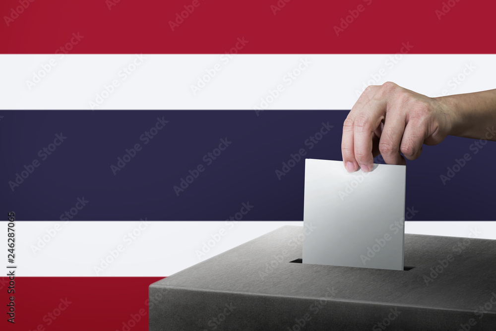 Hand holding ballot paper for election vote at thailand national flag background. Thailand voting concept. Hand holding ballot paper for election vote at thailand national flag background. Thailand voting concept.
