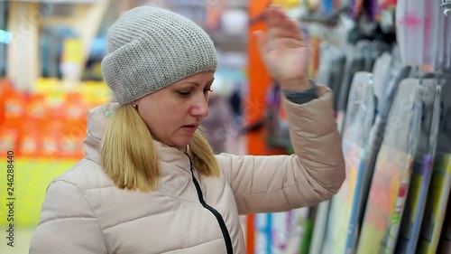 Wallpaper Mural A middle-aged woman in a hat and a down jacket chooses goods in the supermarket. Torontodigital.ca