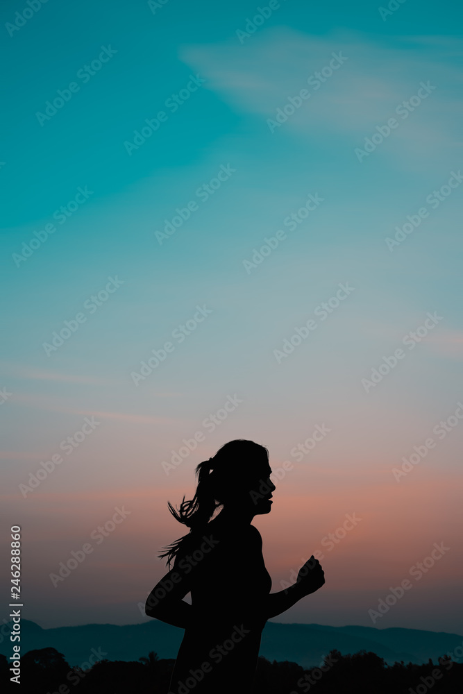 Young woman running at sunrise with mountain natural background.