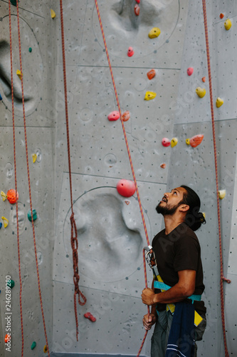 Mixed race male belay Climber in climbing gym