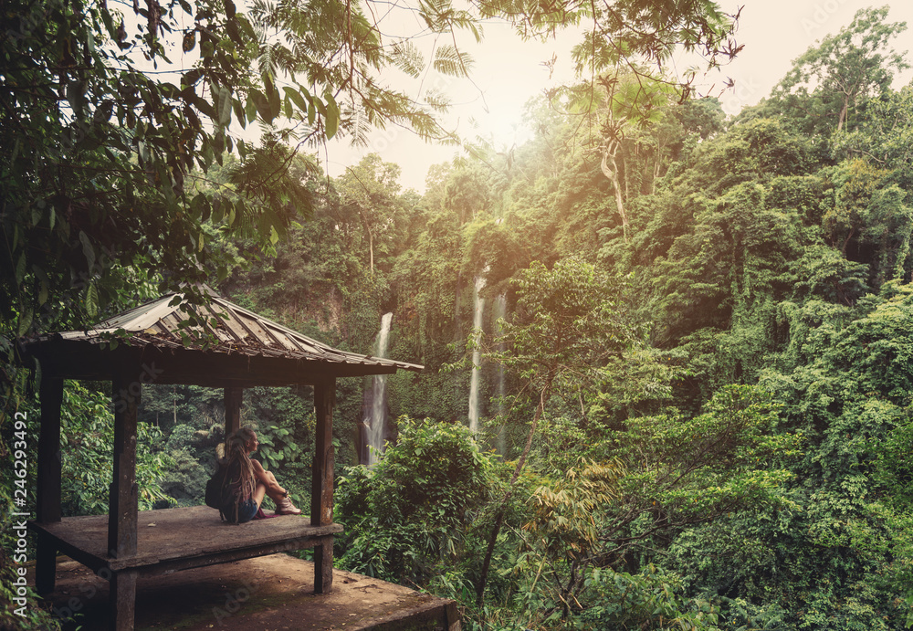Young woman traveler seating in arbour on waterfall view point Young woman traveler seating in arbour on waterfall view point