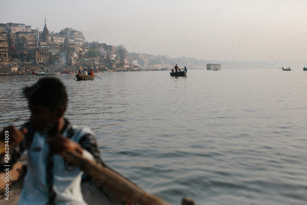Ganga river and Varanasi ghats morning view with buildings from river and boat. Smoke from bonfires