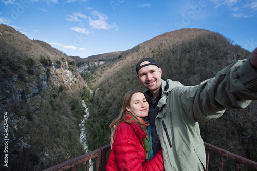 Happy family couple in mountains travel doing selfie