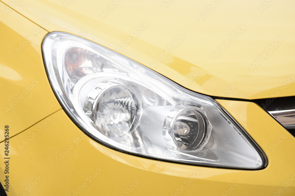 shiny headlight on a yellow  car