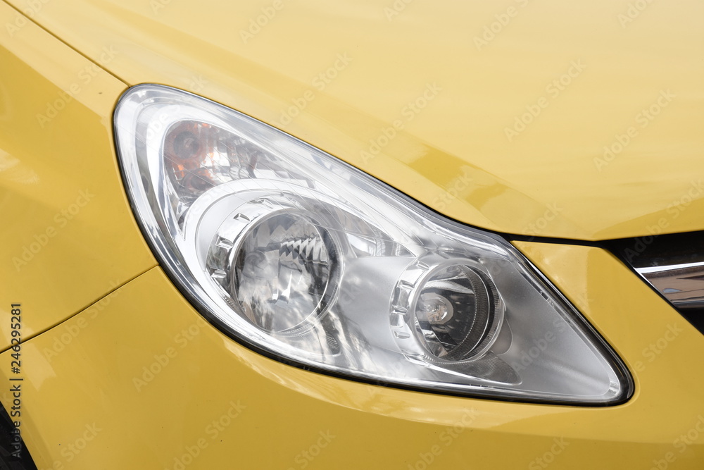 shiny headlight on a yellow  car