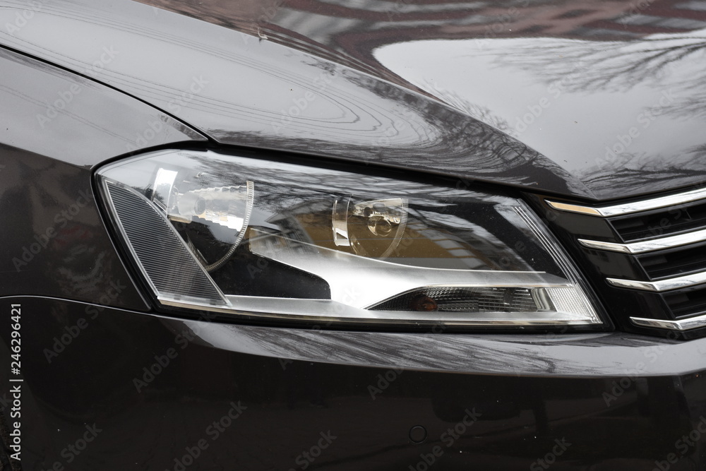 shiny headlight on a  white black  car