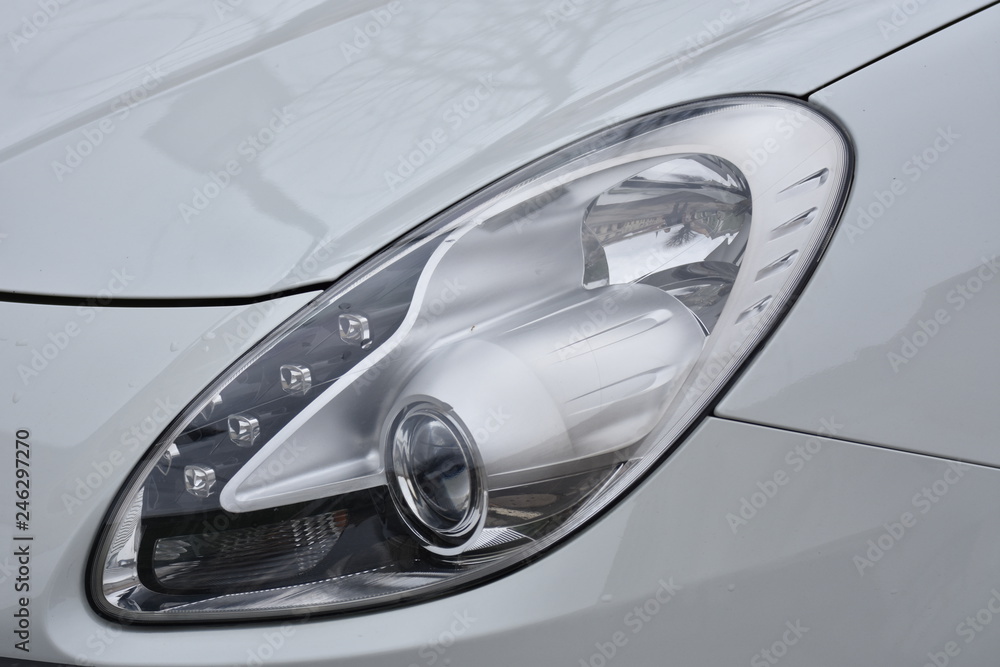  Car's exterior details. shiny headlights on a gray car