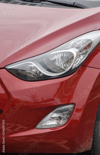  Car's exterior details. shiny headlights on a red car © Laurenx