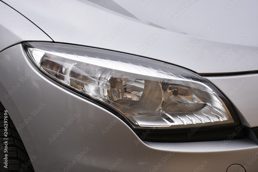 shiny headlights on a white silver car shiny headlights on a white silver car