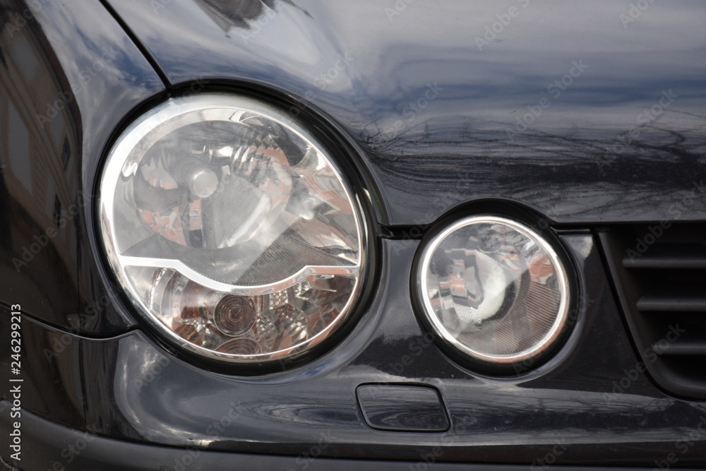 Car'sCar exterior detail.shiny headlight on a black car exterior detail, headlight on a new car Car'sCar exterior detail.shiny headlight on a black car exterior detail, headlight on a new car