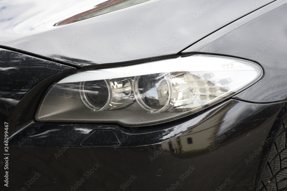 Car'sCar exterior detail.shiny headlight on a black  car exterior detail, headlight on a  new car