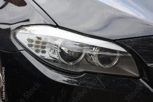 Car'sCar exterior detail.shiny headlight on a black car exterior detail, headlight on a new car