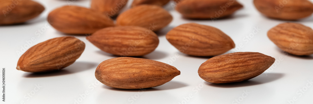 Almond nut scattered on a white background close-up. Almond nut scattered on a white background close-up.