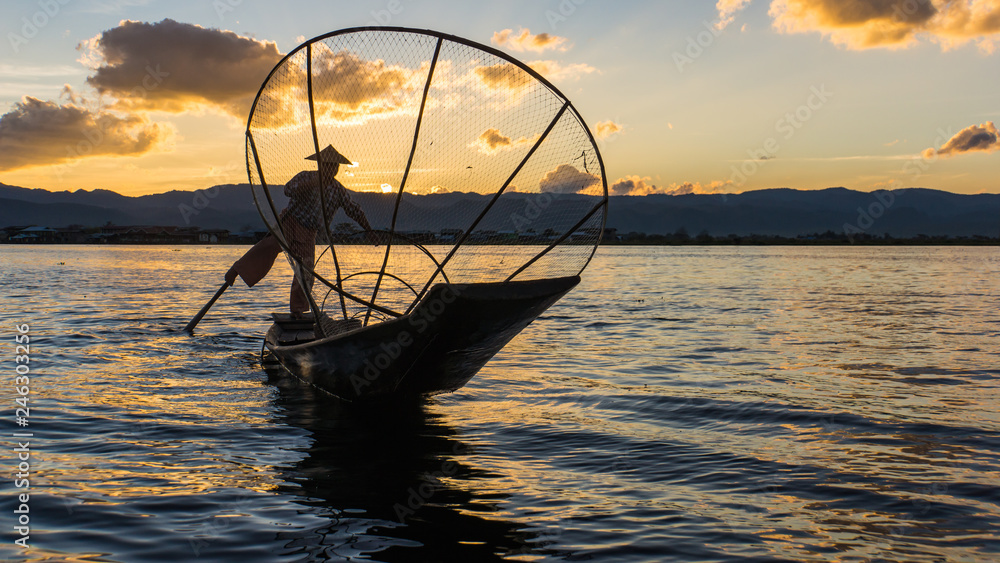 traditional Intha fisherman in long boat in the evening on Lake Inle 
