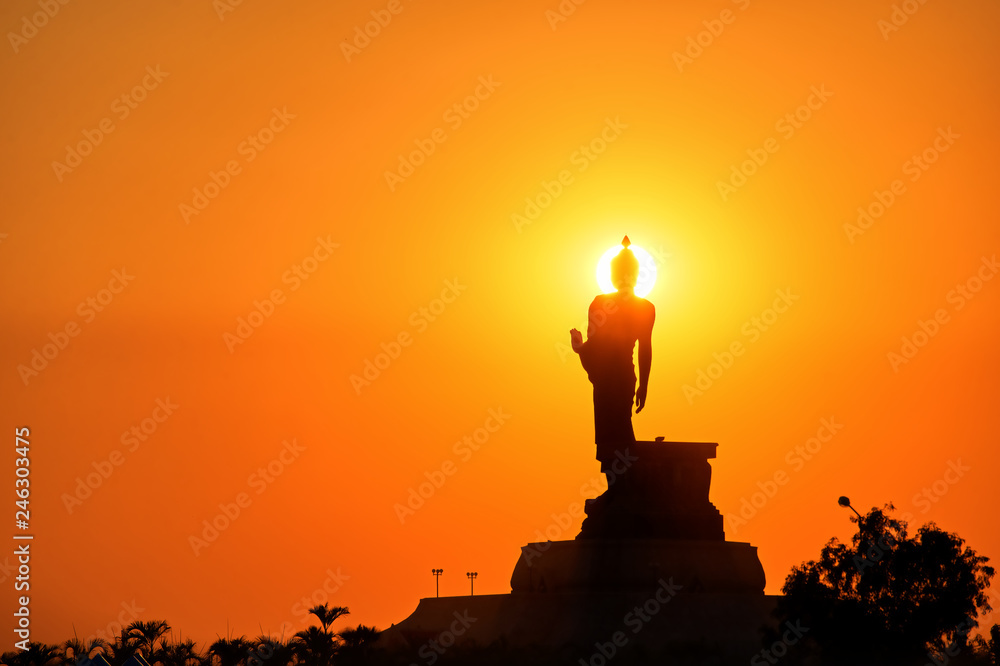 Silhouette Buddha statue on golden sunset background : Khon Kaen, Thailand 