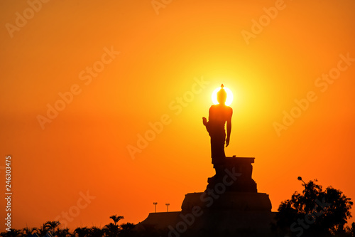 Silhouette Buddha statue on golden sunset background : Khon Kaen, Thailand 