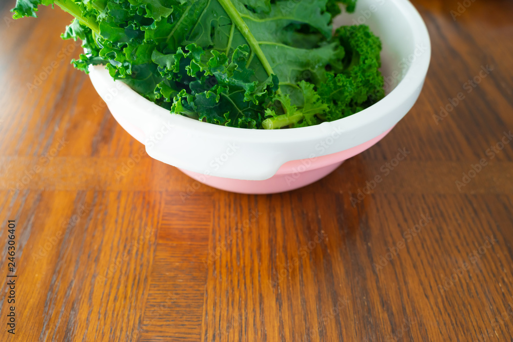 Bunch organic fresh of kale in plastic bowl on table Bunch organic fresh of kale in plastic bowl on table