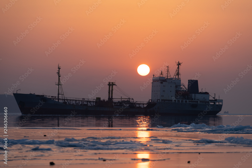 The silhouette of the ship against the sea and a bright sunset.