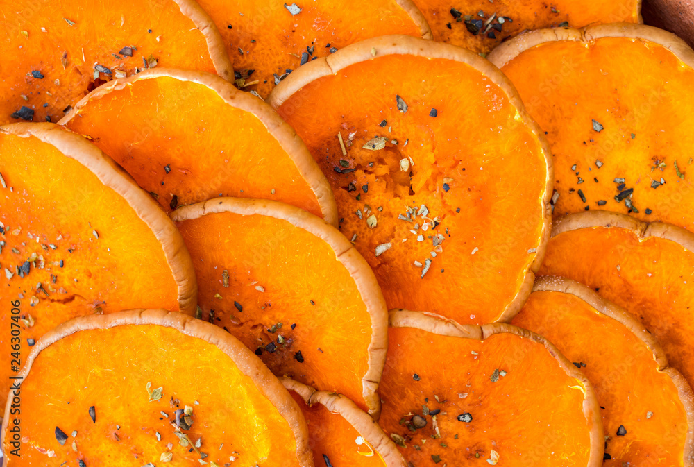 Round pumpkin slices (pieces) baked, grilled in oven with spices and herbs: thyme, oregano, garlic. Vegan, vegetarian healthy food. Round pumpkin slices (pieces) baked, grilled in oven with spices and herbs: thyme, oregano, garlic. Vegan, vegetarian healthy food.
