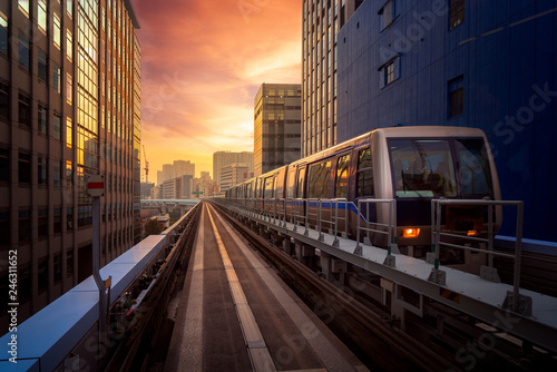 Train in city in Tokyo with sunset background photo