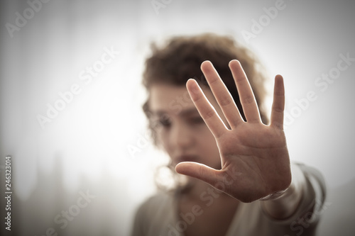 Woman stretching out hand for self-defense or asking for help. concept of stop violence or Domestic violence. Portrait of teenage girls with bruises on her face showing stop sign, palm in focus photo