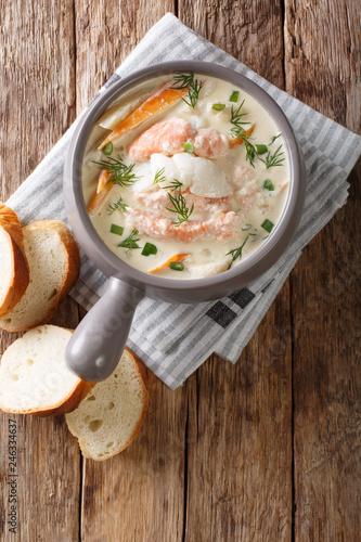 Norwegian creamy fish soup fiskesuppe with cod and salmon closeup. Vertical top view
