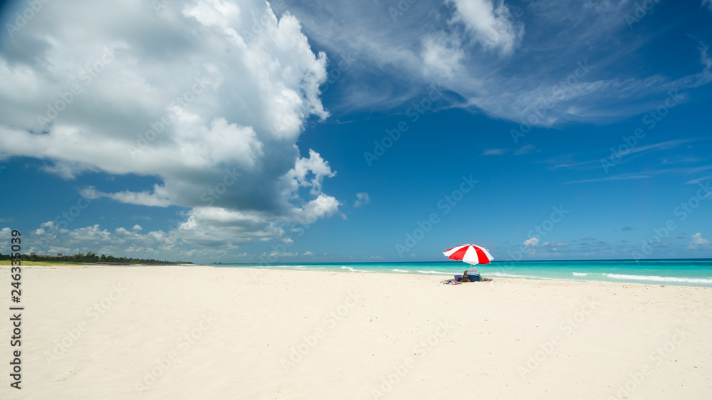 Awesome beach of Varadero during a sunny day, fine white sand and turquoise and green Caribbean sea,on the right one red parasol,Cuba.concept photo,copy space. Awesome beach of Varadero during a sunny day, fine white sand and turquoise and green Caribbean sea,on the right one red parasol,Cuba.concept photo,copy space.
