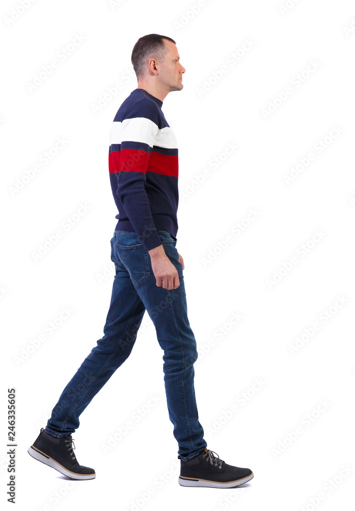 Fototapeta premium Side view of going handsome man in pullover.