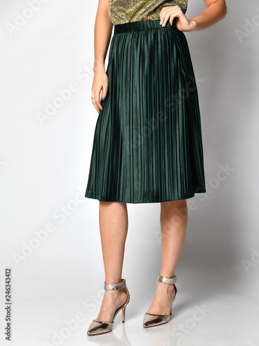 Woman legs in green skirt dress in silver medium hills shoes on gray 