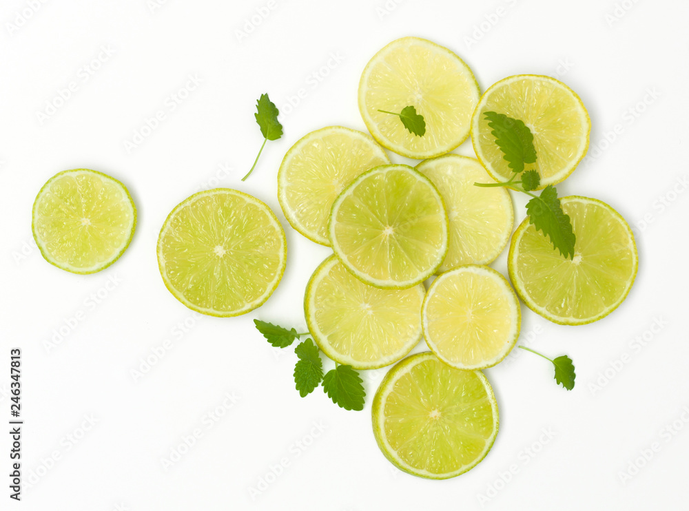 many fresh lime slices with mint are beautifully arranged on a white background