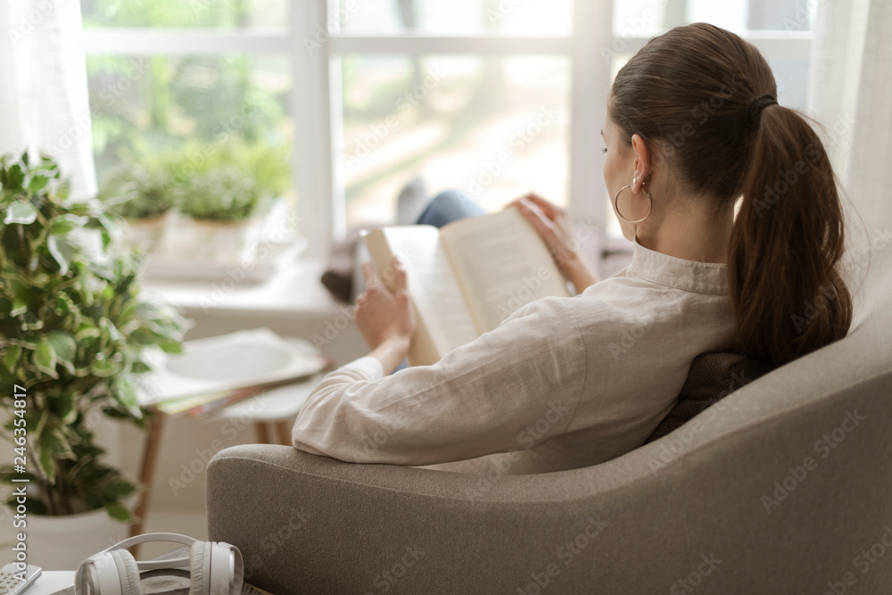 Woman relaxing and reading a book - obrazy, fototapety, plakaty 