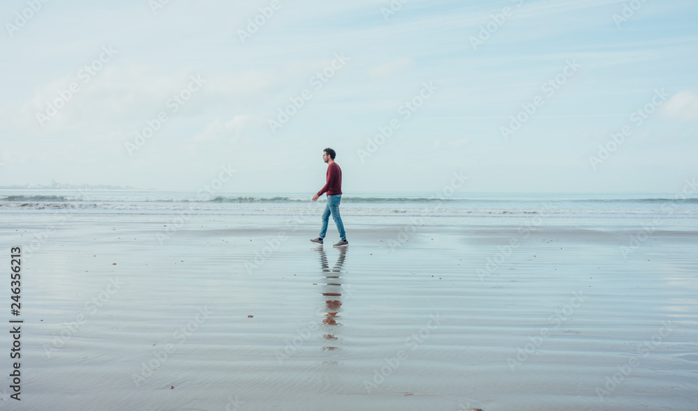Boy walking on the beach at low tide