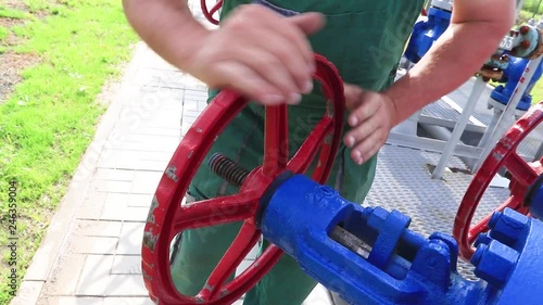 The hands of a young Caucasian worker tightening the valve photo