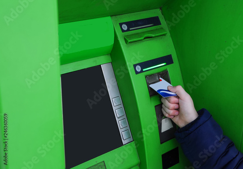 Hand inserting card into cash machine