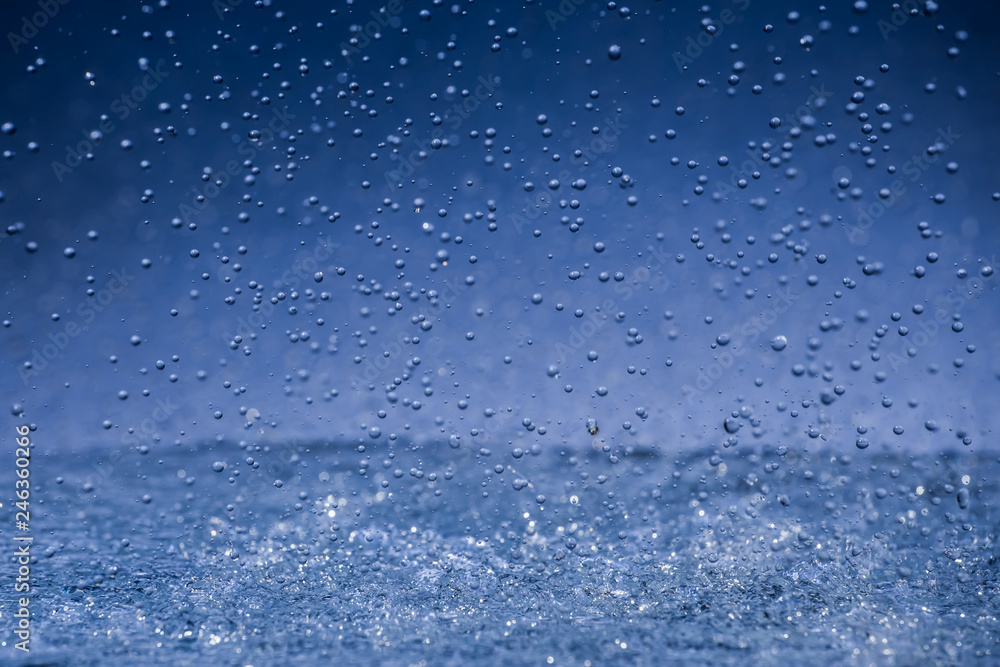 Raindrops crashing to surface on blue background Raindrops crashing to surface on blue background