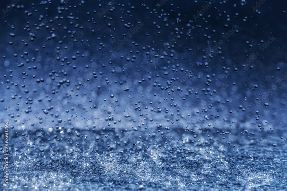 Raindrops crashing to surface on blue background