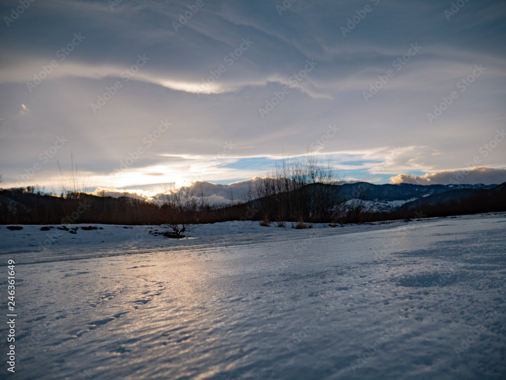 The mountain river in the winter at sunset in Ukraine