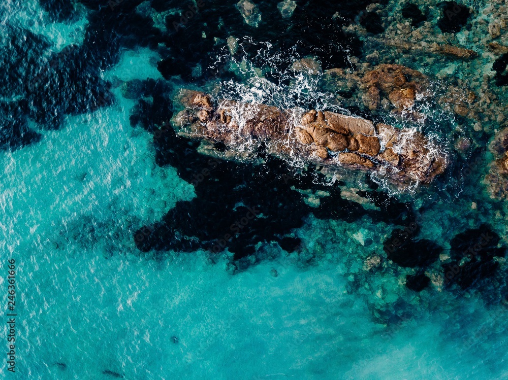 Aerial view of ocean waves and rocks. Blue  sea surface