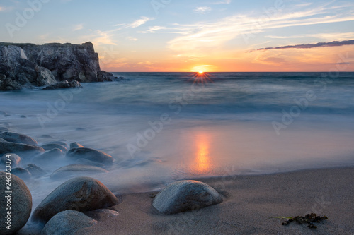French landscape - Bretagne. A beautiful beach with wild cliffs in the background at sunset. © PhotoGranary