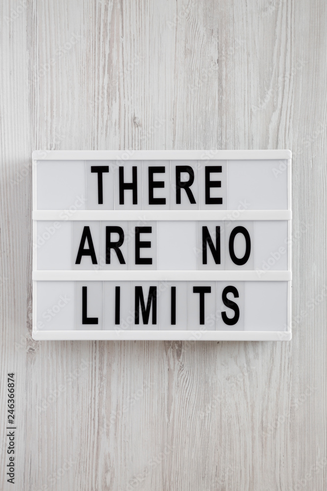 Modern board with text 'There are no limits' on a white wooden background, top view. Flat lay, overhead. Modern board with text 'There are no limits' on a white wooden background, top view. Flat lay, overhead.