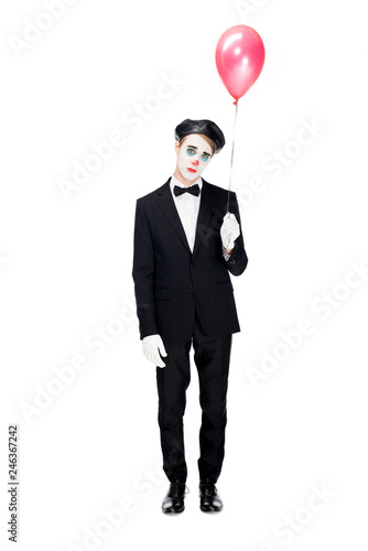 sad clown in suit and black beret holding balloon and standing isolated on white © LIGHTFIELD STUDIOS