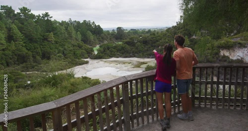 Traveling New Zealand. Tourists couple at Champagne pool at Wai-O-Tapu pools Sacred Waters. Tourist attraction Waiotapu, Rotorua, north island. Active geothermal area, Okataina Volcanic Centre, Taupo. photo