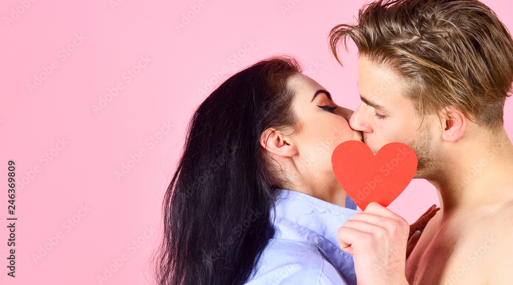 Celebrate valentines day. Romantic kiss concept. Couple in love kissing and hide lips behind heart card. Sensual kiss of lovely couple close up. Man and woman romantic kiss. Love and foreplay Celebrate valentines day. Romantic kiss concept. Couple in love kissing and hide lips behind heart card. Sensual kiss of lovely couple close up. Man and woman romantic kiss. Love and foreplay