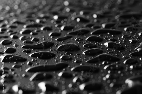 Water droplets on black background and texture, macro, side view