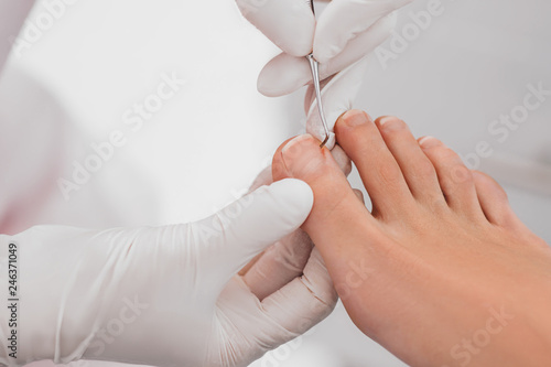 Podolog removes the cuticle on the nails using hardware.